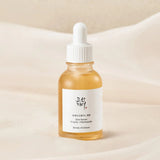 Beauty of Joseon Glow Serum bottle with dropper featuring Propolis and Niacinamide on a soft fabric background.