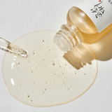 Beauty of Joseon Glow Serum in a glass bottle with a dropper, showcasing the golden serum texture and bubbles.